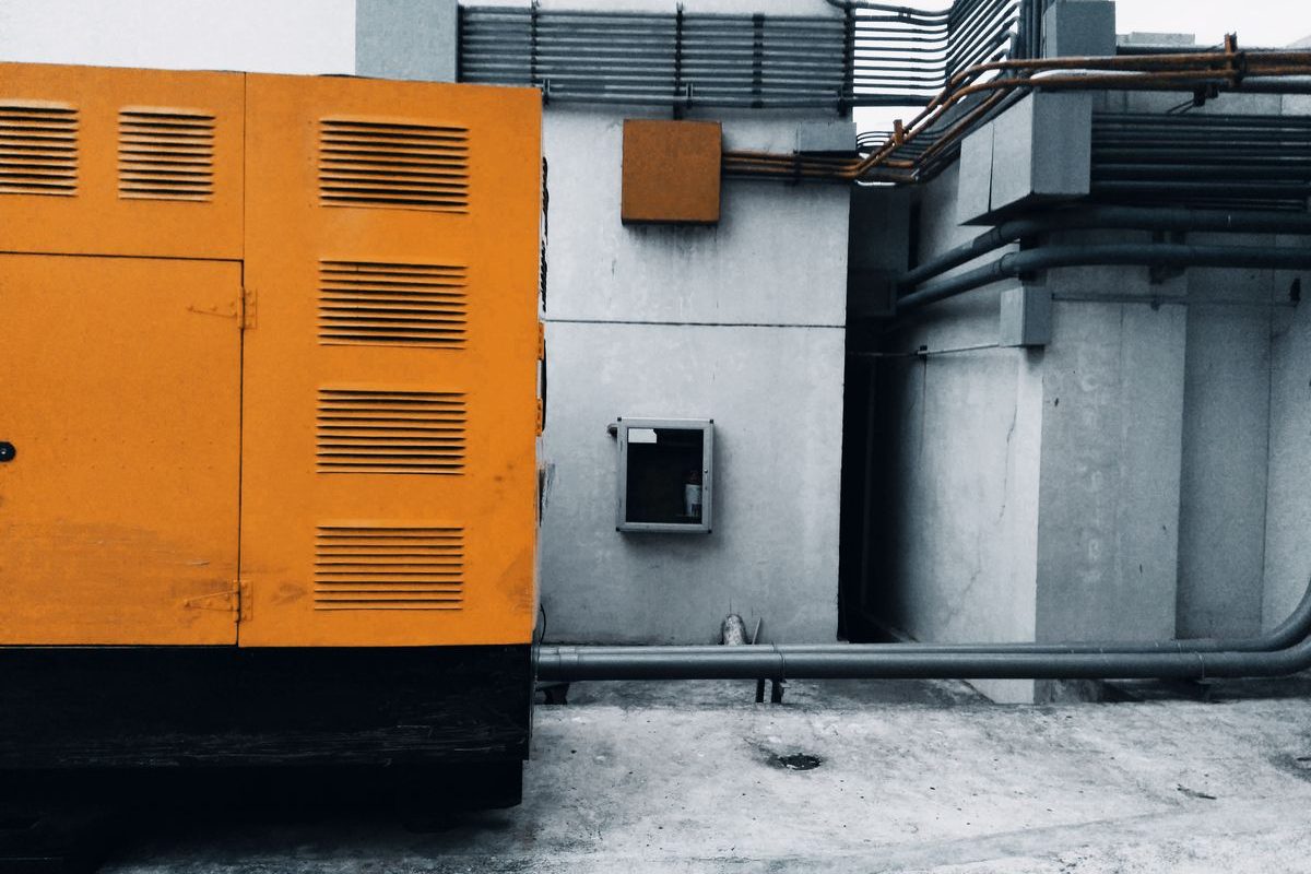 An enclosed industrial generator outside a building